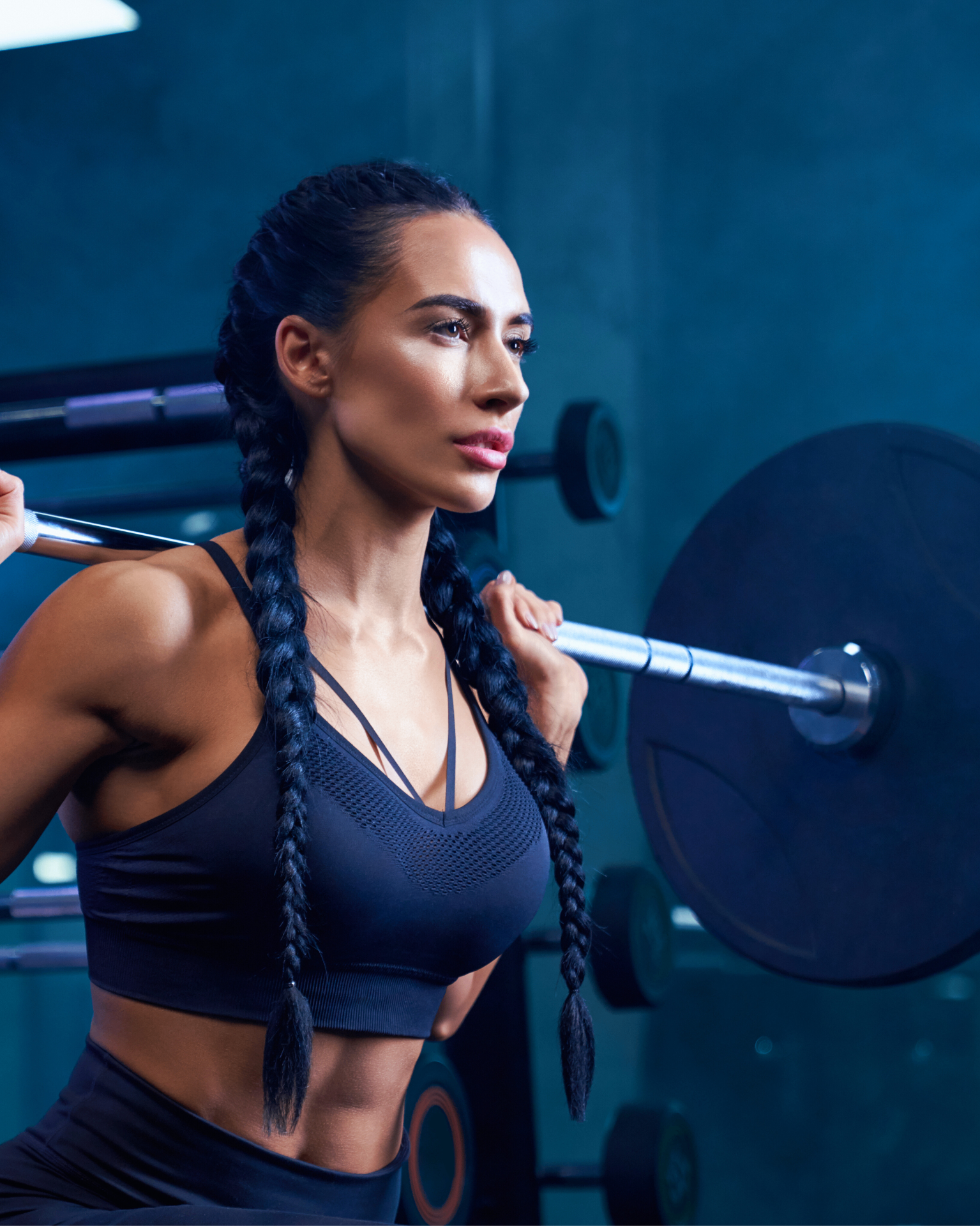 Coach Giba accompagnant une cliente dans un exercice de musculation
